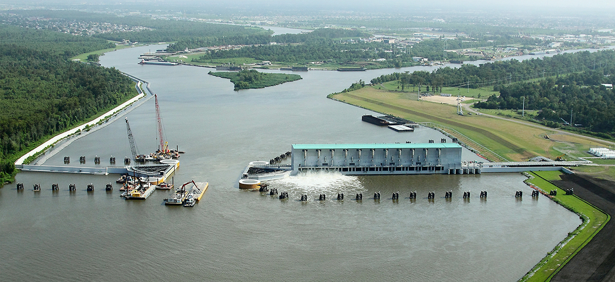 Overhead view of a flood control structure in a river surrounded by greenery